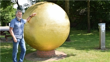 Der Ideengeber: Andreas Brunkhorst an der mit Blattgold überzogenen Sonne im Anderlinger Ortskern, dem Startpunkt des Steinplanetariums.