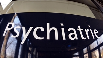 Ein Schild mit der Aufschrift "Psychiatrie" an einem Gebäude. 