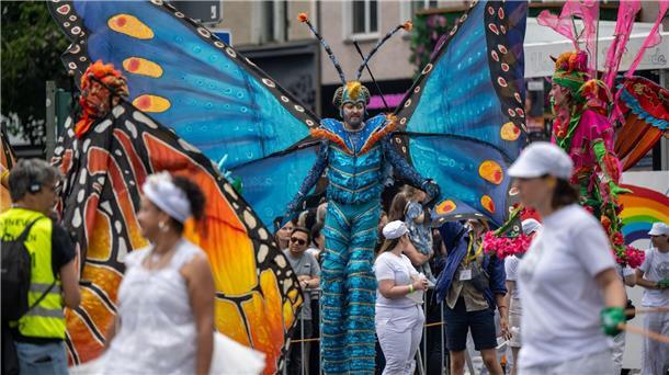 Der international geprägte Straßenumzug mit Musik- und Tanzgruppen zieht Tausende Besucher an.