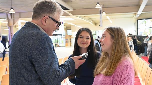 Fake News im Visier: Faktencheck für Schülerinnen und Schüler Ein älterer Mann und zwei junge Frauen im Gespräch.