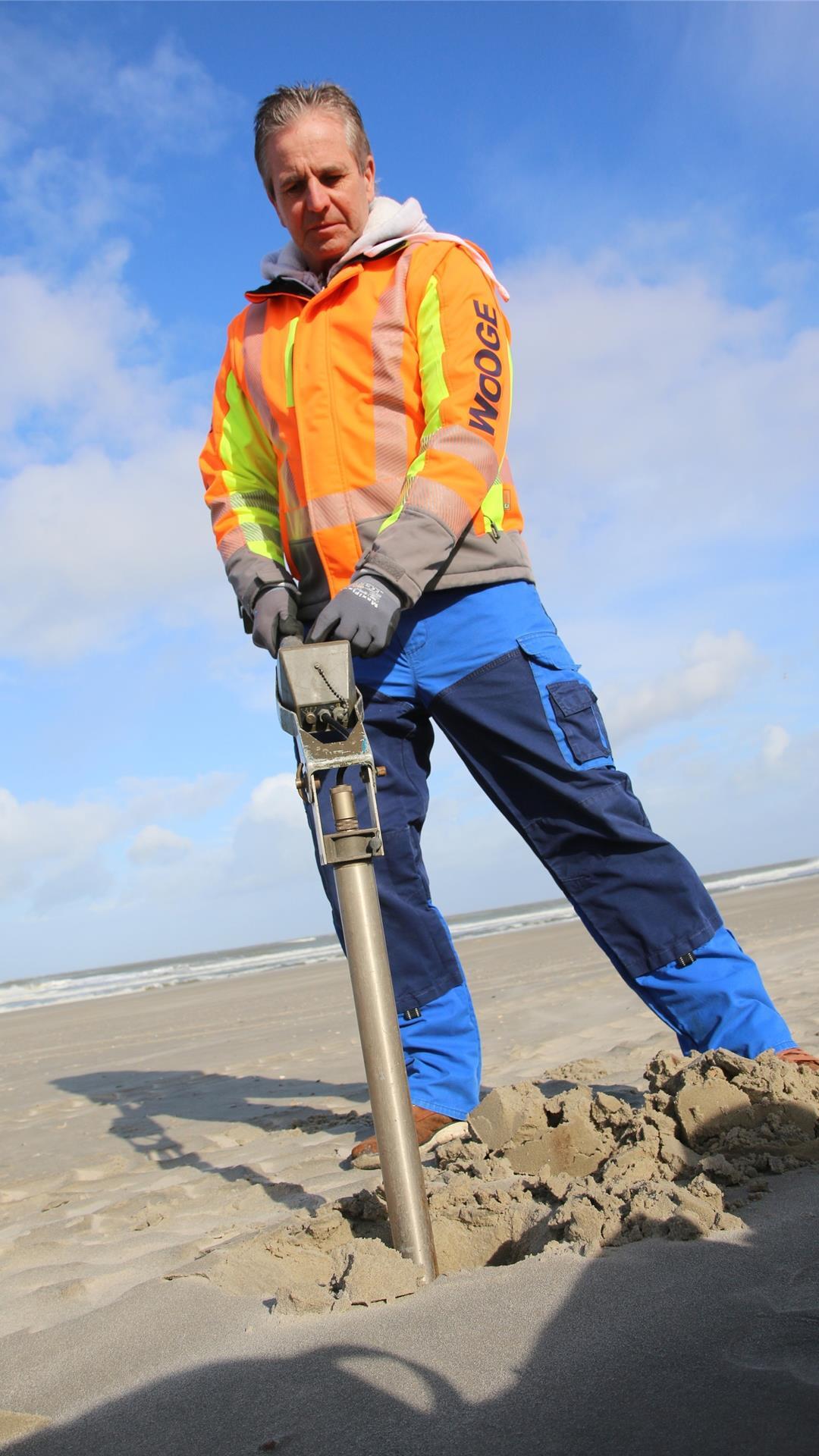 Der Kampfmittelräumer Hans Warfsmann steht auf dem Strand von Wangerooge und sucht mit Hilfe einer Sonde nach alter Munition.
