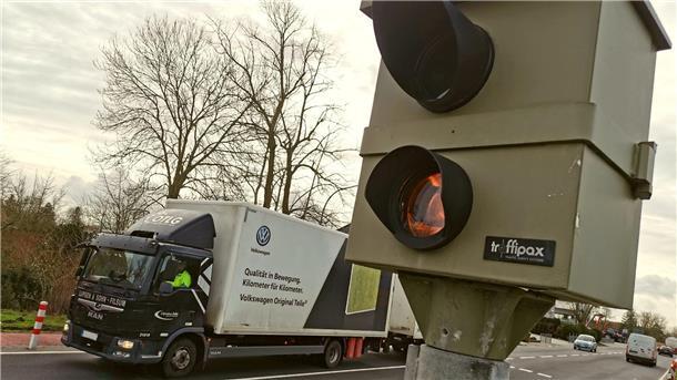 Stationärer Blitzer an einer Straße, im Hintergrund fährt ein Lastwagen