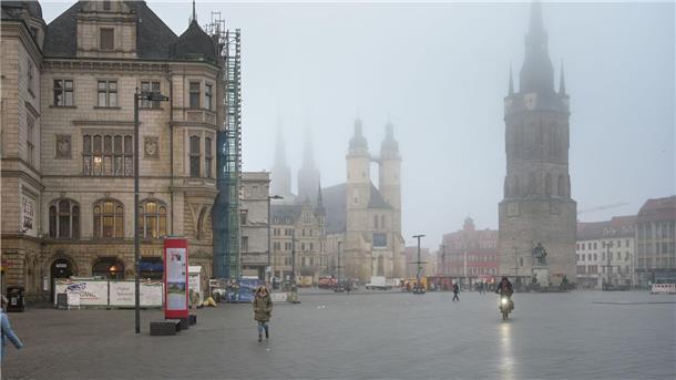 Der Marktplatz von Halle im Morgennebel mit dem Roten Turm und der Marktkirche.