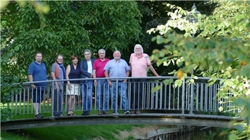 7 ältere Leute auf einer Brücke