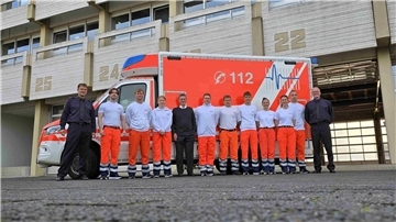 Menschen stehen vor einem Rettungswagen