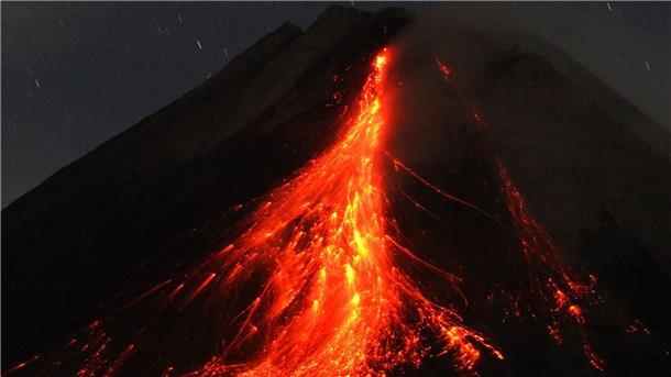 Lava strömt aus indonesischem Vulkan Merapi Der orange-rote Lavastrom leuchtet in der Dunkelheit.
