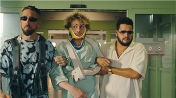 Szene aus dem Film „Der Prank – April, April“: Ein Pizzabote, der unter anderem einen verletzten Arm hat, wird nach einem Unfall aus dem Krankenhaus entführt - von zwei ernst guckenden Männern, die jeweils Sonnenbrillen tragen. Steckt die Mafia dahinter? 