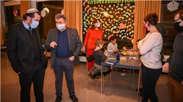 Der Rabbiner der liberalen jüdischen Menorah-Gemeinde, Tobias Jona Simon (links), diskutiert mit dem Vorsitzenden Mircea Ionescu, während Kinder sich mit Basteln die Zeit vertreiben.