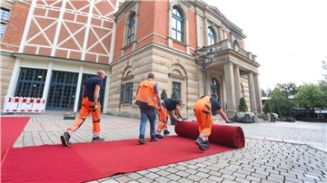 Der rote Teppich wird vor dem Bayreuther Festspielhaus ausgerollt.
