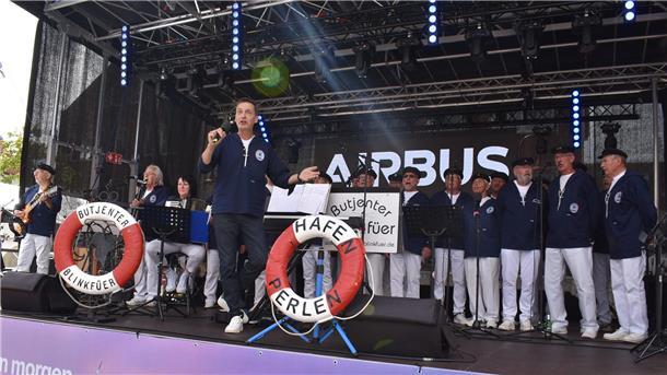 Ein Chor auf einer Bühne_ Der Shantychor „Butjenter Blinkfüer“ unter Leitung von Hergen Hasemann begeisterte mit maritimen Liedern beim Stadtfest in Nordenham. 