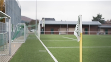 Eine Eckfahne steht am Rand eines Fussballplatzes.