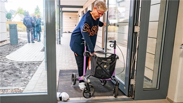 Der Stäwog-Neubau an der Isarstraße in Bremerhaven-Surheide ist noch nicht komplett bezogen, darum stoßen Mieter mit Rollstuhl oder Rollator - wie hier Karin Coordes - derzeit noch auf „Barrieren“ wie diese nicht automatische Eingangstür.