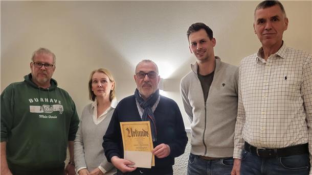 Hauptversammlung der TSG Burhave: Dieses Mitglied ist besonders geehrt worden Fünf Leute stehen bei der Jahreshauptversammlung der TSG Burhave nebeneinander.