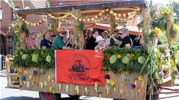 Ein Festwagen fährt durch eine Straße. 