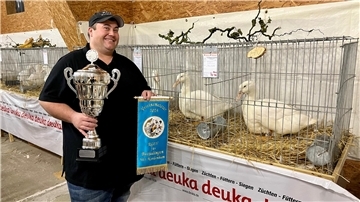 Mann neben zwei Enten bei Geflügelschau
