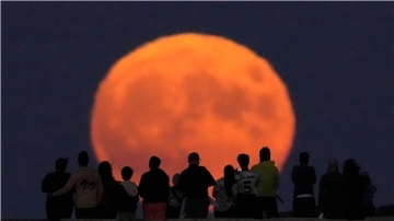 Der Vollmond erhebt sich über dem Lake Michigan.
