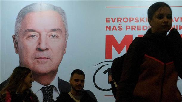 Der Wahlkampf ist zu Ende: Menschen gehen an einem Plakat des pro-westlichen Amtsinhabers Milo Djukanovic vorbei.