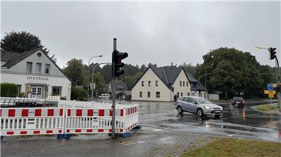 Eine Straßenkreuzung, auf der Autos verkehren. Links ist eine Straßensperrung zu sehen: Sie hegt die B71 ein.