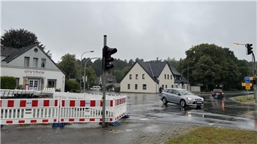 Eine Straßenkreuzung, auf der Autos verkehren. Links ist eine Straßensperrung zu sehen: Sie hegt die B71 ein.