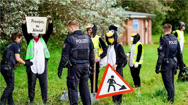 Die Aktivistin werden von Polizisten überprüft.