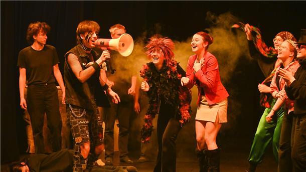 Schülerinnen und Schüler unterschiedlichen Alters spielen gemeinsam auf der Theaterbühne