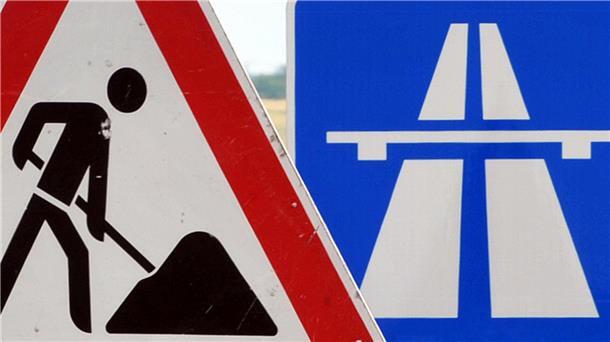  Ein Baustellenschild ist vor einem Autobahnschild platziert. 