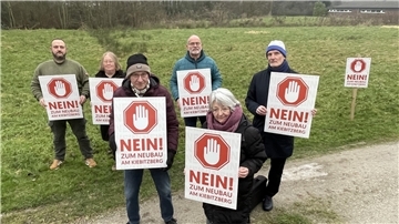 Eine Gruppe von Menschen mit Protestschildern. Anwohner der Straße Am Kiebitzberg in Nordenham wehren sich gegen eine dort geplante Wohnbebauung.