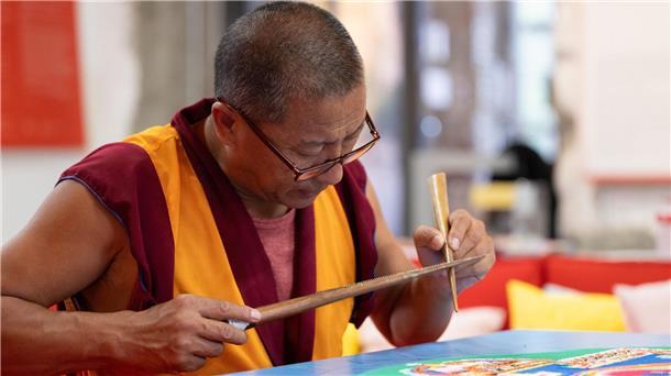Die Arbeit am Sandmandala erfordert Ruhe und Geduld.