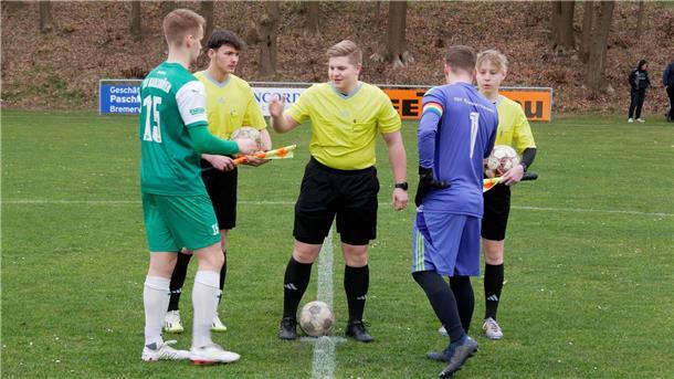 Die Assistenten Tetje Hausschild und Justin Sieling sowie Schiedsrichter Jonte Martens (Mitte) begrüßen die Kapitäne vom TSV Karlshöfen und TSV Bülstedt/ Vorwerk.