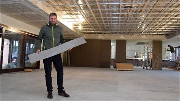 Die Bauarbeiten im Rockstedter „Haus im Löh“ schreiten voran. Der stellvertretende Gemeindebürgermeister Volker Borchers zeigt den Belag, der den Fußboden zieren soll.