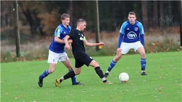 Zwei Männer laufen hinter einem Ball her.