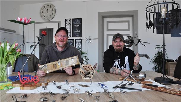 Zwei Männer mit Schmuckgegenständen, die vor ihnen auf dem Tisch liegen. Heiko Bahlmann (links) und Ralf Schmidt präsentieren neue kunsthandwerkliche Arbeiten aus dem Arbeitslosenzentrum
