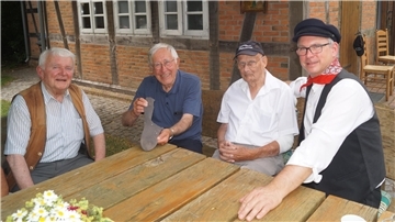 Die Brüder Peter (von links) und Bernd Klingner erklären Willi Voß, wer einst welchen Teil der Socke strickte. Oliver von Studnitz ist heute im Vorstand des Heimatvereins und freut sich über dieses Zusatzwissen zur Sammlung.