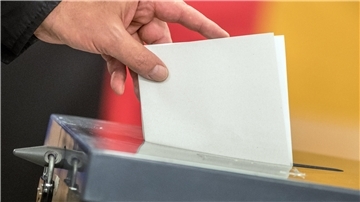 Wähler wirft seinen Stimmzettel zur Bundestagswahl in die Wahlurne
