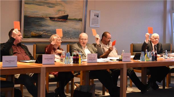 Abstimmung während einer Gemeinderatssitzung in Stadland. Das Foto zeigt die Mitglieder der CDU-Fraktion, die alle mit einer roten Karte gegen ein Vorhaben abstimmen.