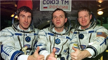 „Unwahrscheinlichste Maschine“: 25 Jahre Crew auf der ISS Die Crew, die als erste die Internationale Raumstation ISS bewohnte: US-Astronaut Bill Shepherd (l-r) und die russischen Kosmonauten Juri Gidsenko und Sergej Krikaljow, heben die Daumen vor ihrer Sojus-Rakete. (Archivbild)