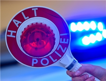 Eine Kelle der Polizei mit der Aufschrift Halt Polizei vor einem Blaulicht eines Polizeifahrzeuges. Die Cuxhavener Polizei kontrollierte am Wochenende zahlreiche Verkehrsteilnehmer, von denen einige ihre Fahrt nicht fortsetzen durften. 