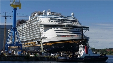 ein neu gebautes Kreuzfahrtschiff liegt in einem Hafen