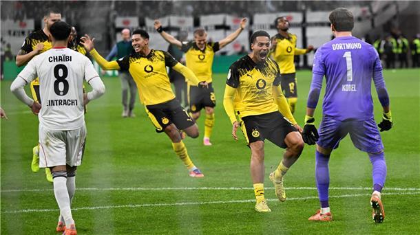 Die Dortmunder Spieler stürmen auf Elfmeter-Held Kobel zu.