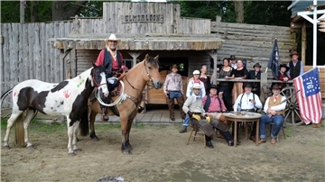 Zwei Pferde und Menschen im Western-Look