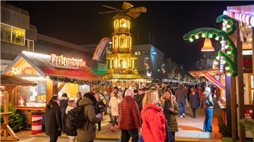 Die ersten Gäste des Bremerhavener Weihnachtsmarkt schlenden an den Buden vorbei.