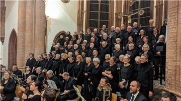 150 Jahre Christuskirche: Mozarts Messe in c-Moll eröffnet Festwoche Ein großer gemischter Chor in schwarzen Konzertkleidern steht in der Christuskirche Bremerhaven vor den hohen gotischen Fenstern.