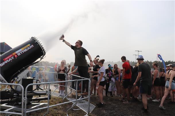 Die Festival-Besucher suchen Abkühlung unter der Fontäne.