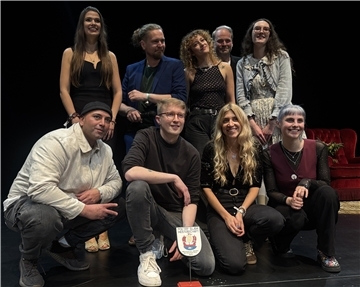 Finale mit Tiefgang: Matti Linke gewinnt Poetry-Slam-Meisterschaft Gruppenfoto der Teilnehmenden der niedersächsischen Poetry-Slam-Meisterschaft im Stadttheater Bremerhaven. Acht Personen stehen und knien auf der Bühne, in der Mitte ist die Siegerplakette zu sehen.