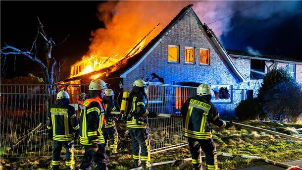 Ein Bauernhaus steht in Flammen. Die Feuerwehr bekämpft den Brand.