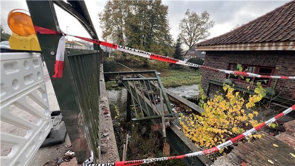 Kaputte Gitter, ein rotes Backsteinhaus und rot-weiße Absperrbänder.