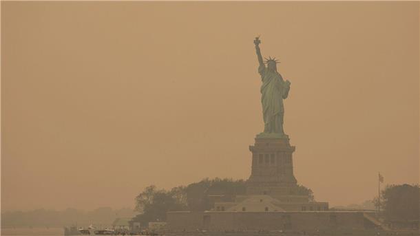 Rauch von Waldbränden hüllt New York ein Die Freiheitsstatue ist in orangefarbenen Dunst gehüllt.