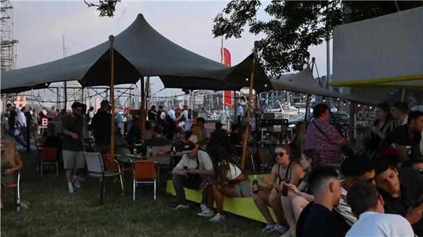 NEUS Festival 2025: Musik, Kultur und ausgelassene Stimmung am Wasser Die Gäste auf dem Neus Festival genießen die letzten Sonnenstrahlen.