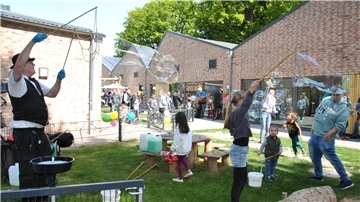 Die Gäste haben viel Spaß bei der Einweihung der Quartierskindergärten an der Molkereistraße in Zeven. Die riesigen Seifenblasen kommen bei Groß und Klein gut an.