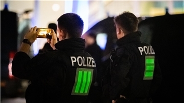 Zwei Polizeibeamte machen Aufnahmen mit dem Handy